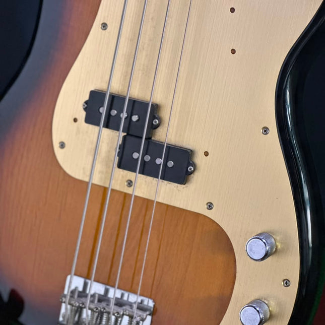 Fender Precision Bass pickups and chrome bridge on 2-tone sunburst body.