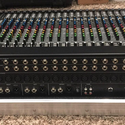 Analog mixer rear panel with large rows of input/output connectors on a road case