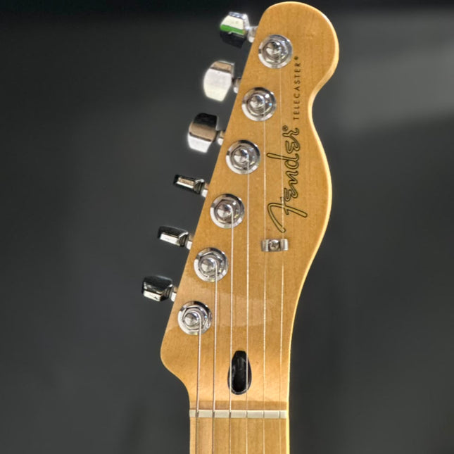 Fender electric guitar headstock with maple neck, chrome tuners, and Fender logo