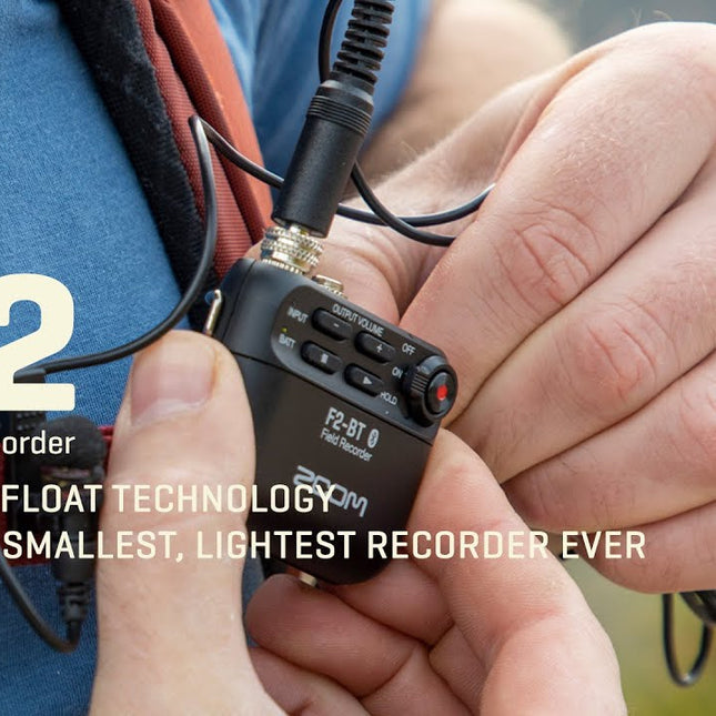 Black field recorder held in hand with clip-on lavalier microphone