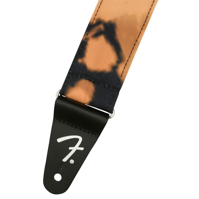Black guitar strap end with Fender logo and tan/orange tie-dye webbing