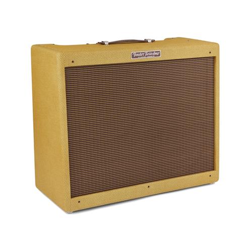 Angled view of tweed guitar amplifier combo with front grille and control knobs